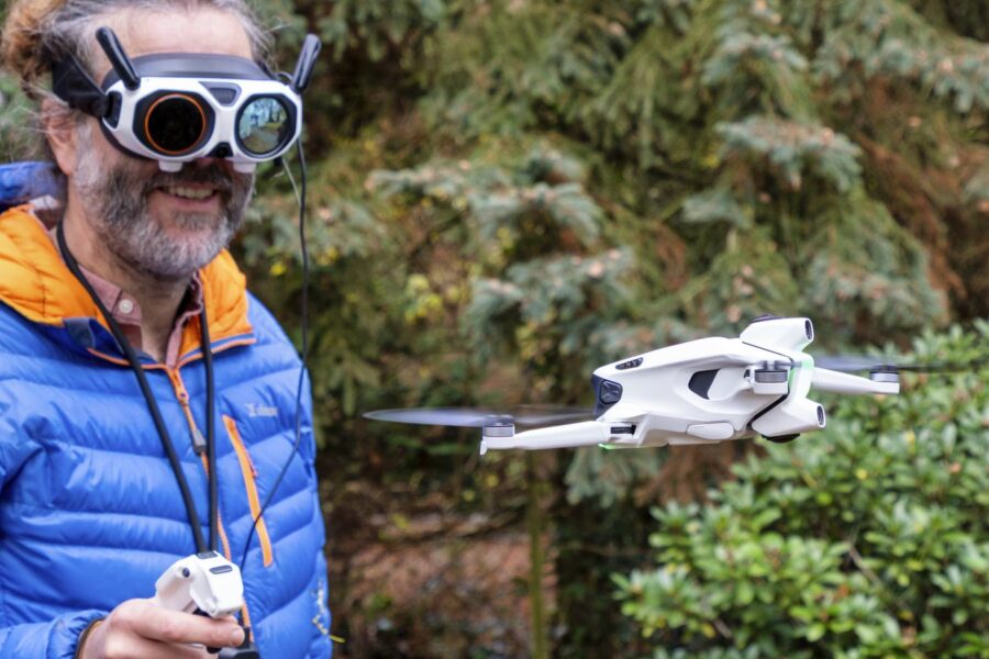 Marc grinst mit FPV-Brille und Grip-Controller, die Antigravity A1 schwebt neben ihm