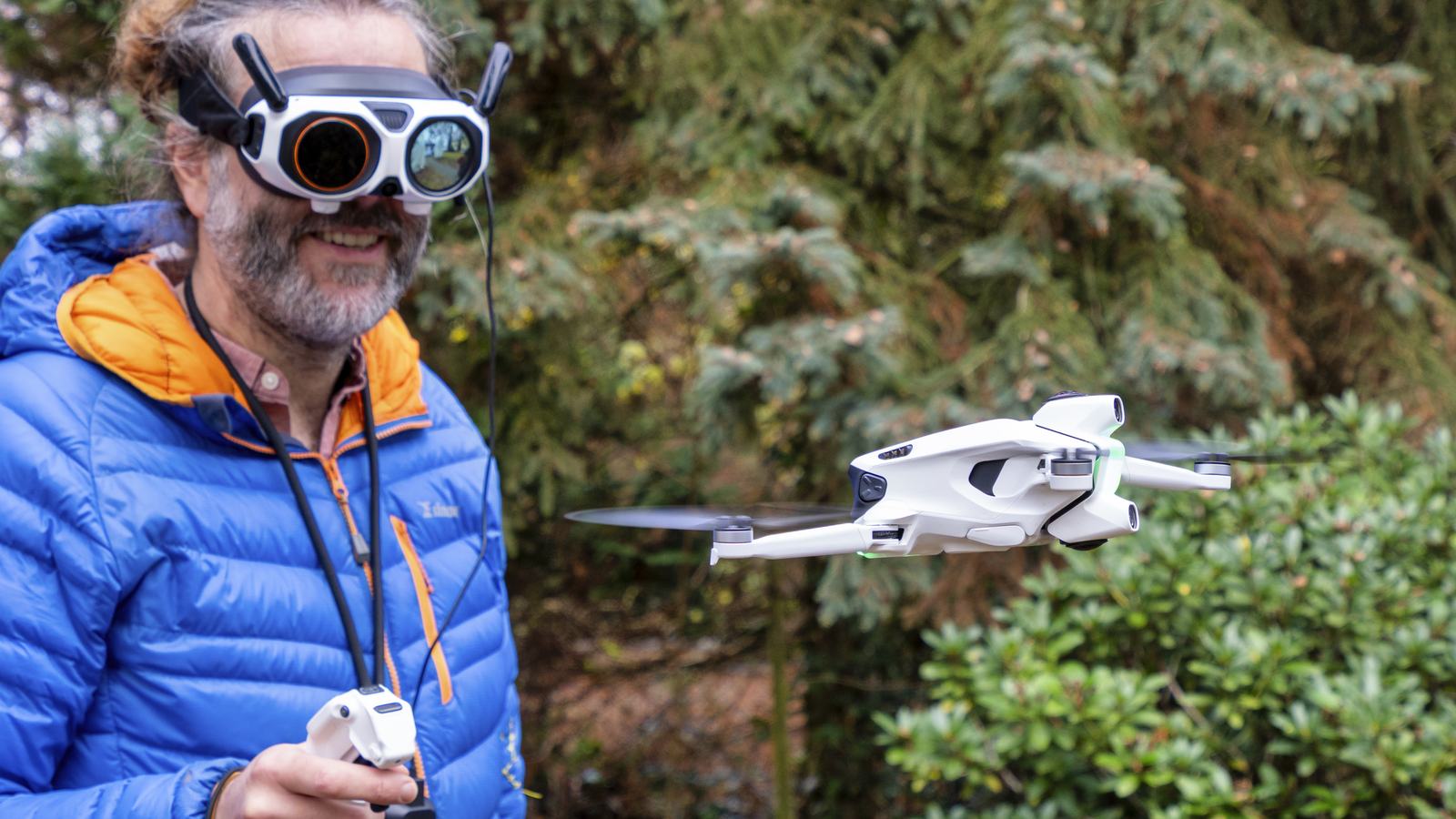 Marc grinst mit FPV-Brille und Grip-Controller, die Antigravity A1 schwebt neben ihm