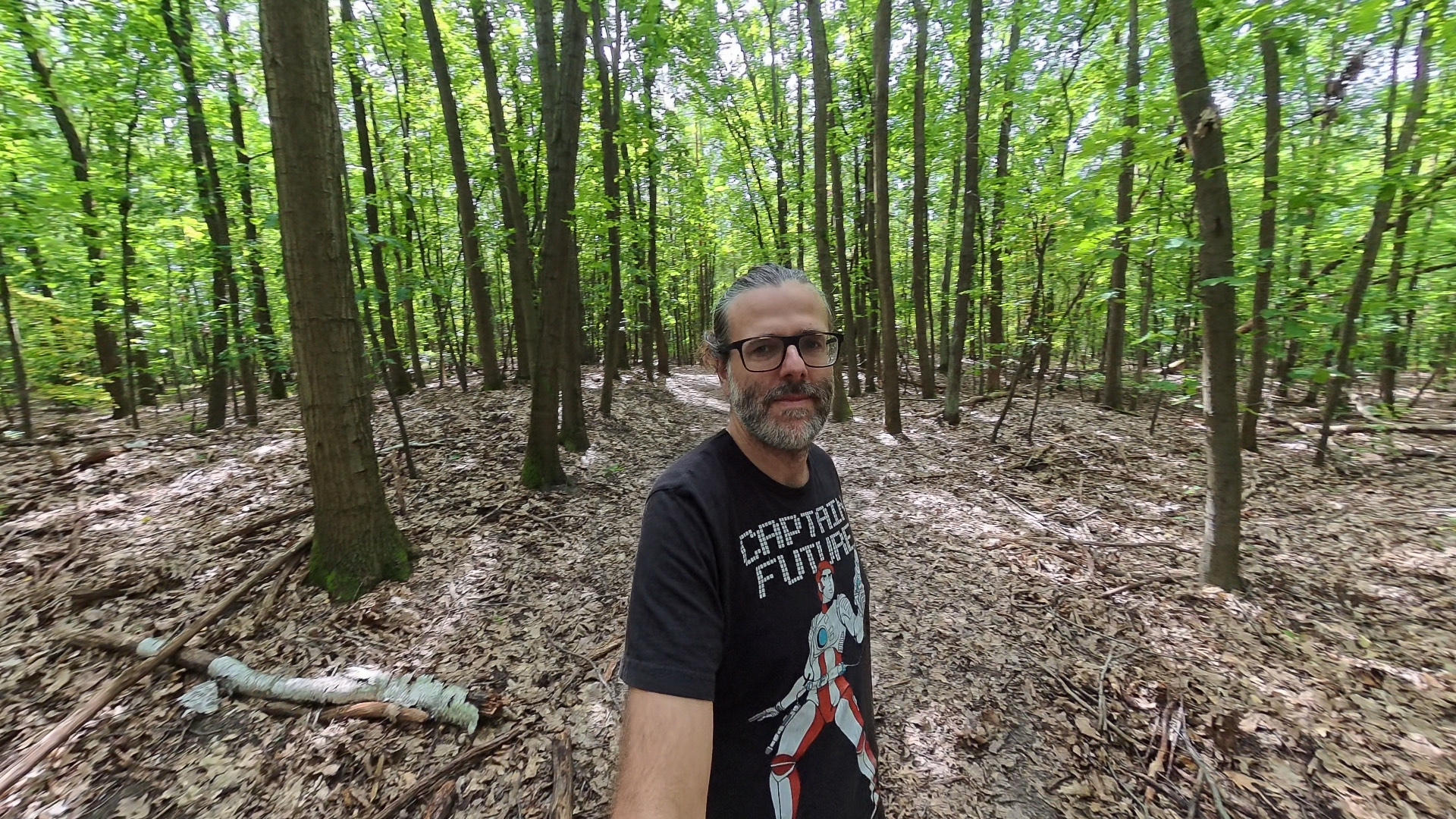 Derselbe Waldweg als Ausschnitt aus einem 8K-360°-Video der Insta360 X5: mehr Details in Rinde und Laub, im Hintergrund ausgefressene Sonnenflecken